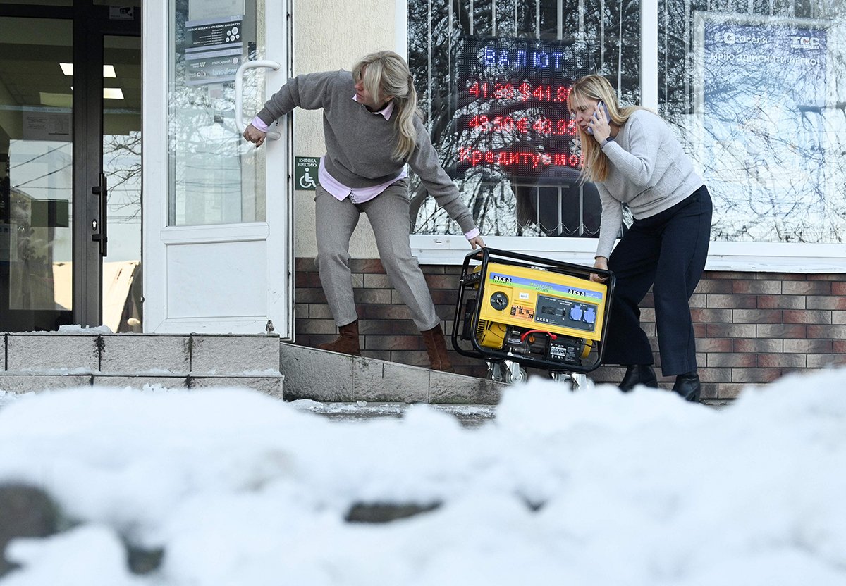 Сотрудники банка закатывают в помещение генератор, Львов, Украина, 13 декабря 2024 года. Фото: AFP / Scanpix / LETA / Yuriy Dyachyshyn