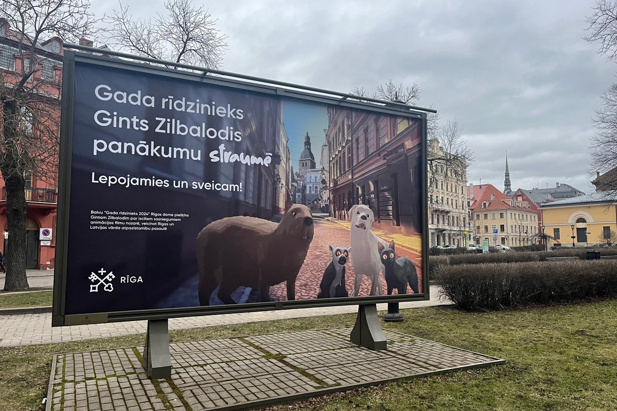 Плакат с мультфильмом «Поток» у Старого города. Надпись: «Рижанин года Гинтс Зилбалодис в потоке успеха. Мы гордимся и поздравляем!». Фото: Фото: «Новая-Европа»