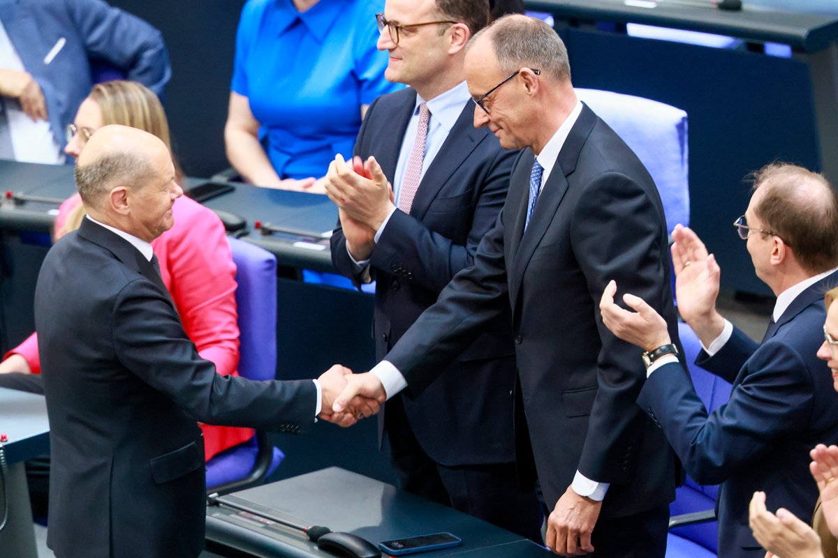 Уходящий с поста канцлера Германии Олаф Шольц (слева) поздравляет вновь избранного канцлера Фридриха Мерца (в центре) после второго тура голосования в Бундестаге, Берлин, 6 мая 2025 года. Фото: Hannibal Hanschke / EPA