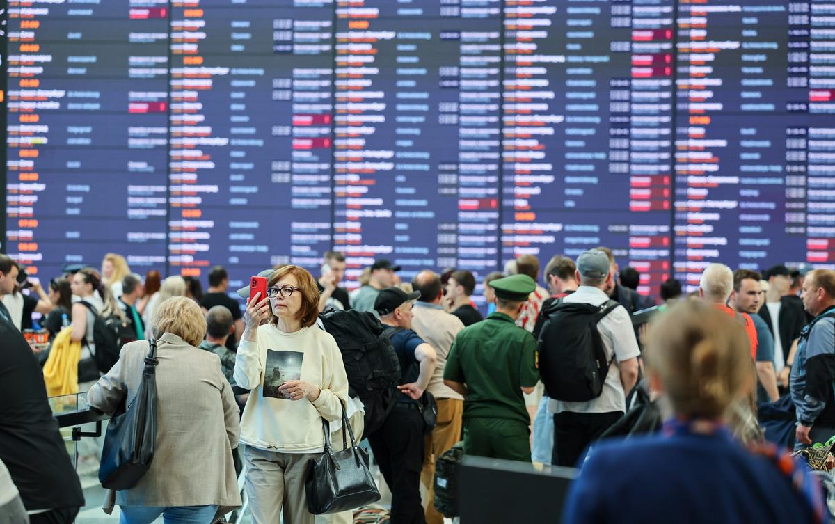A passenger examines her mobile phone at Sheremetyevo Airport, Moscow, 7 July 2025. Photo: EPA/YURI KOCHETKOV
