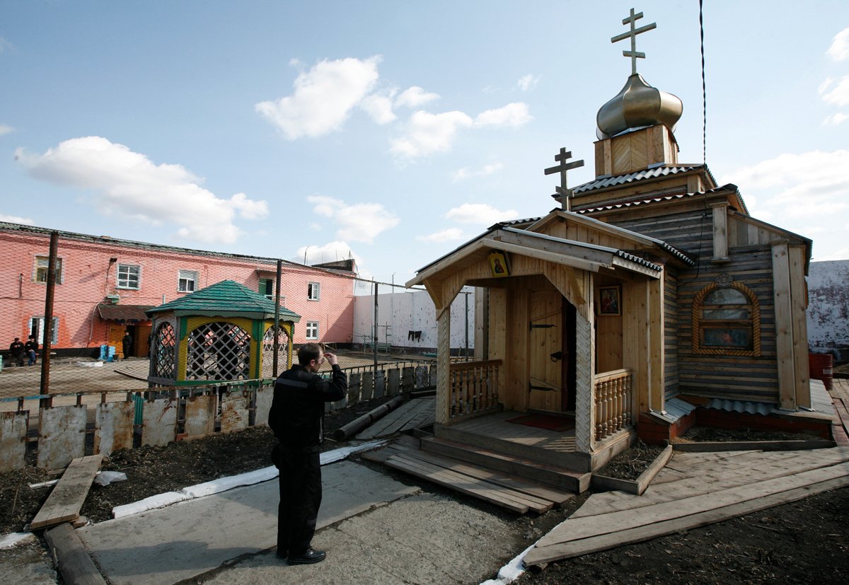Заключенный крестится перед православной церковью в колонии строгого режима в селе Арийск, Красноярский край, 23 апреля 2013 года. Фото: Илья Наймушин / Reuters / Scanpix / LETA