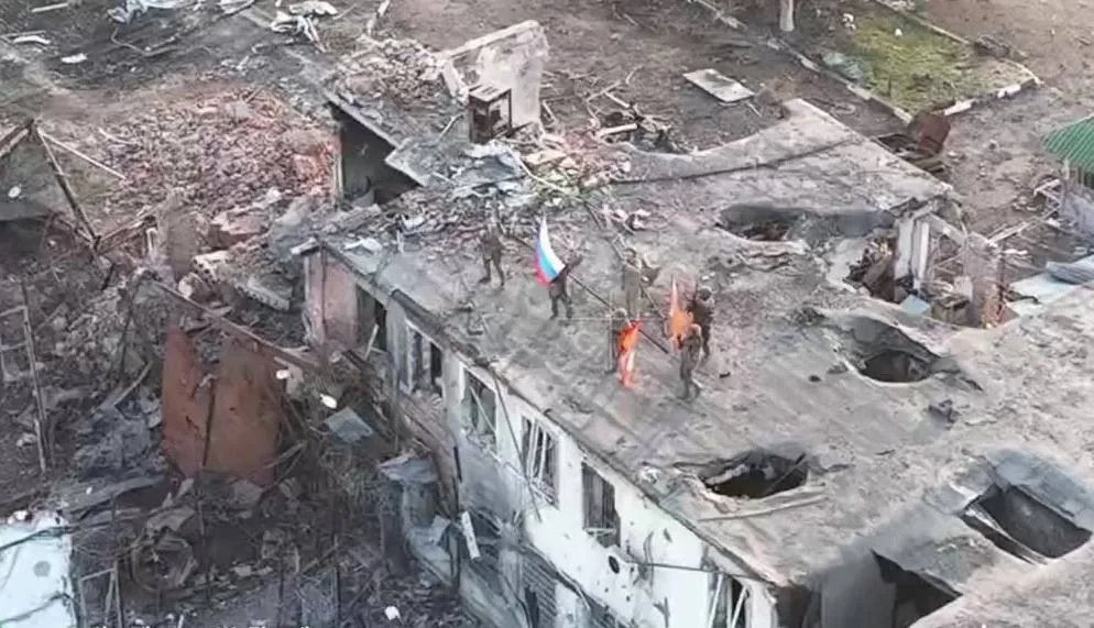 Russian servicemen raise the Russian flag on a building in Malaya Loknya, Kursk region, 9 March 2025. Still from Russian Defence Ministry footage