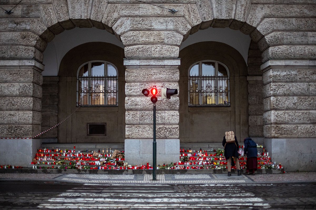 Люди возлагают цветы перед главным зданием Карлова университета, 23 декабря 2023 года. Фото: Martin Divisek / EPA-EFE