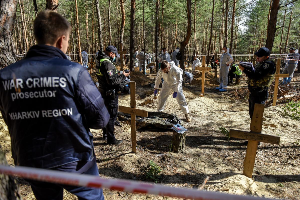 War crimes investigators exhume bodies from a cemetery in Izyum, in eastern Ukraine’s Kharkiv region, 22 September 2022. Photo: EPA-EFE / OLEG PETRASYUK