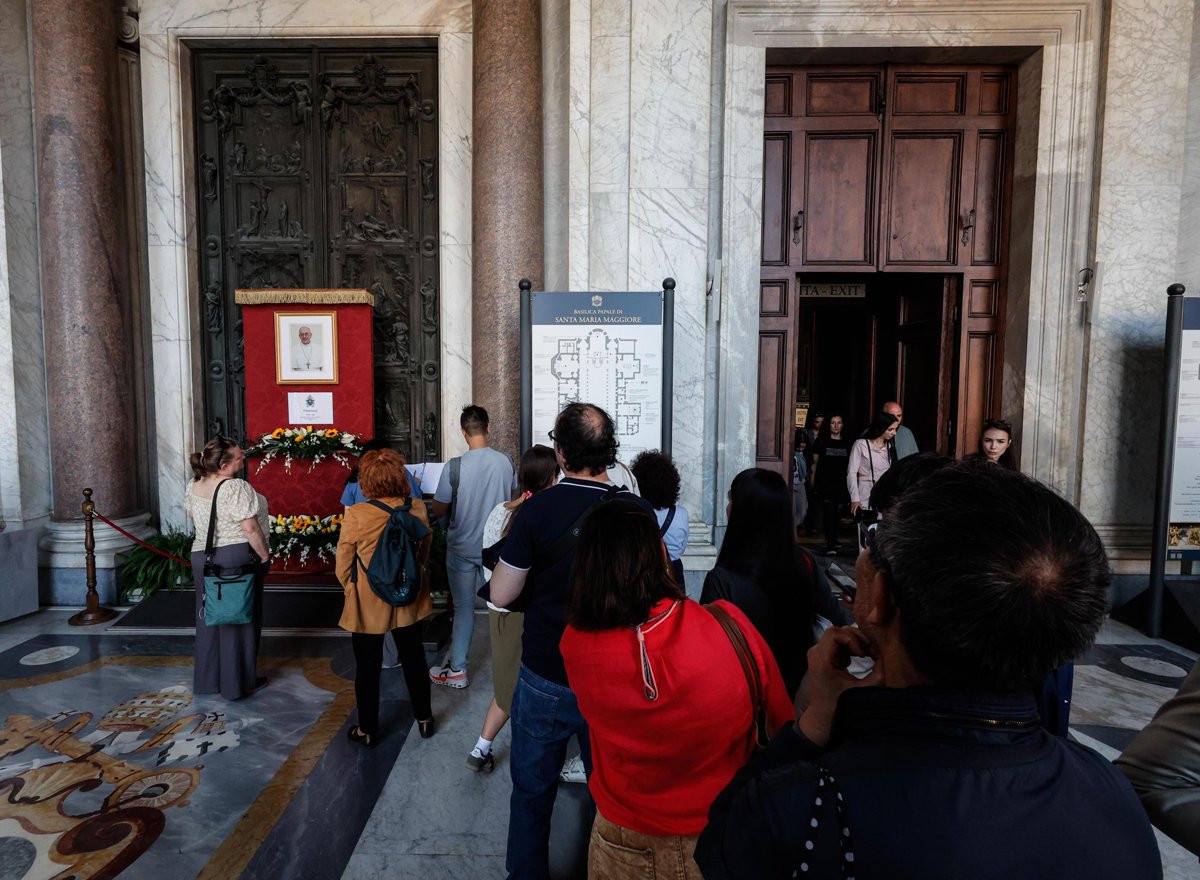 Люди у фотографии Папы Франциска в базилике Санта-Мария-Маджоре в Риме, 21 апреля 2025 года. Фото: Giuseppe Lami / EPA