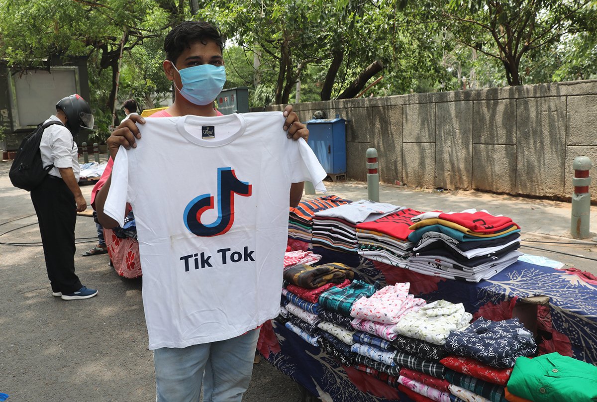 Продавец демонстрирует футболку с логотипом китайского приложения для обмена видео TikTok, Нью-Дели, Индия, 30 июня 2020 года. Фото: Rajat Gupta / EPA-EFE