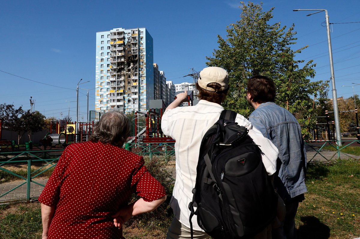 Местные жители смотрят на последствия попадания дрона в Раменском, 10 сентября 2024 года. Фото: Юрий Кочетков / EPA