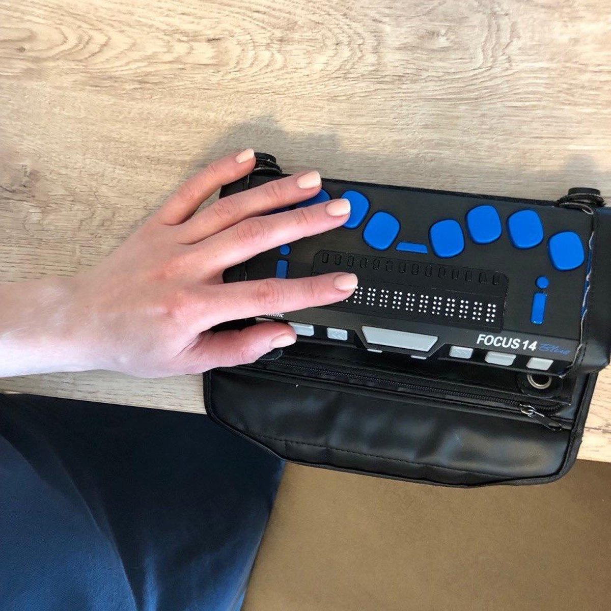 Алена читает сообщение из мессенджера с помощью брайлевского дисплея.